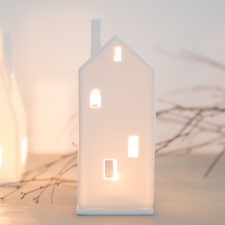 Maison haute lumineuse en porcelaine blanche mate Räder avec fenêtres ajourées et porte agrandie pour bougie