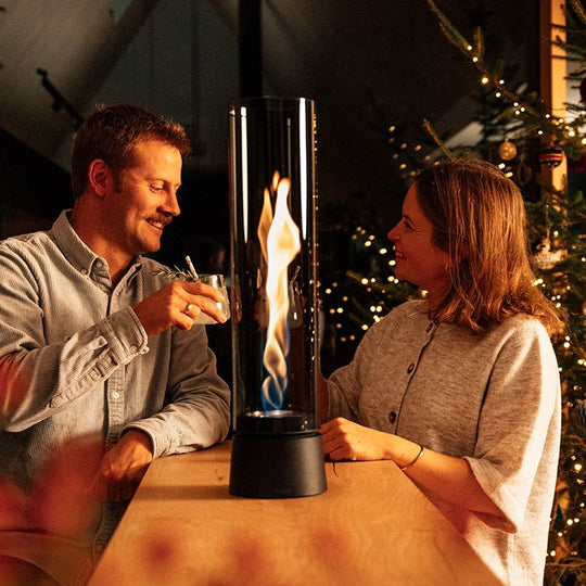 Lanterne design Höfats Spin Air 1200 noire allumée sur une table de terrasse.